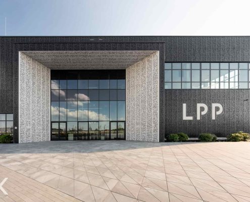 Zdjęcie budynku centrum dystrybucyjnego od strony wejścia, z logo LPP na ścianie po prawej