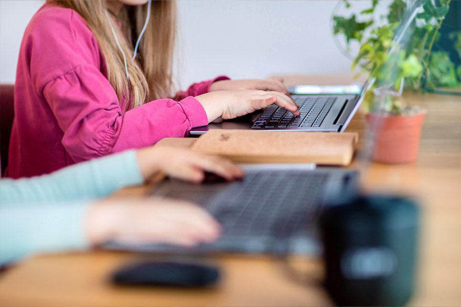 Dziewczynki uczą się na laptopach w programie stypendialnym LPP