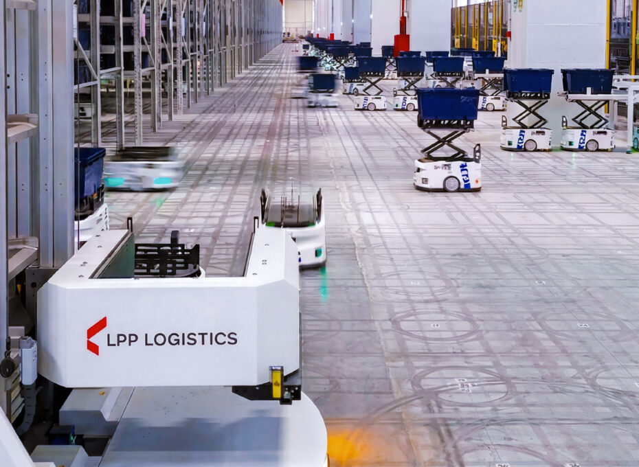 Autonomous warehouse with self-driving robots moving blue bins in a spacious logistics facility, LPP LOGISTICS branding on a foreground cart
